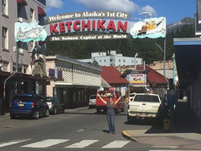 A team member under the sign for Ketchikan